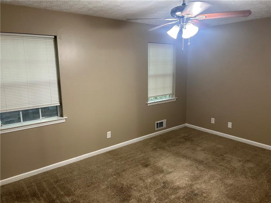 5323 Scarbrough Round Stone Mountain, GA 30088 - Photo 10 of 13 an empty room with windows and fan