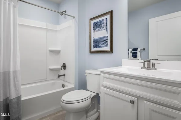 a bedroom with a bed windows and a lamp