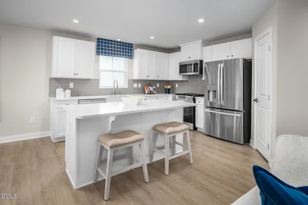 a kitchen with a sink stove cabinets and wooden floor