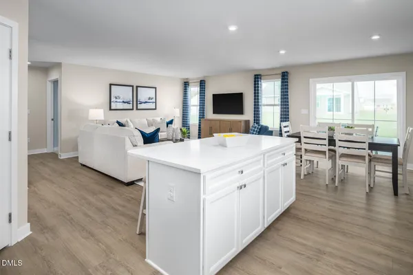 a kitchen with stainless steel appliances a refrigerator a stove a sink and chairs