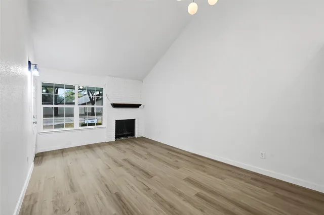 a view of a room with wooden floor and fireplace