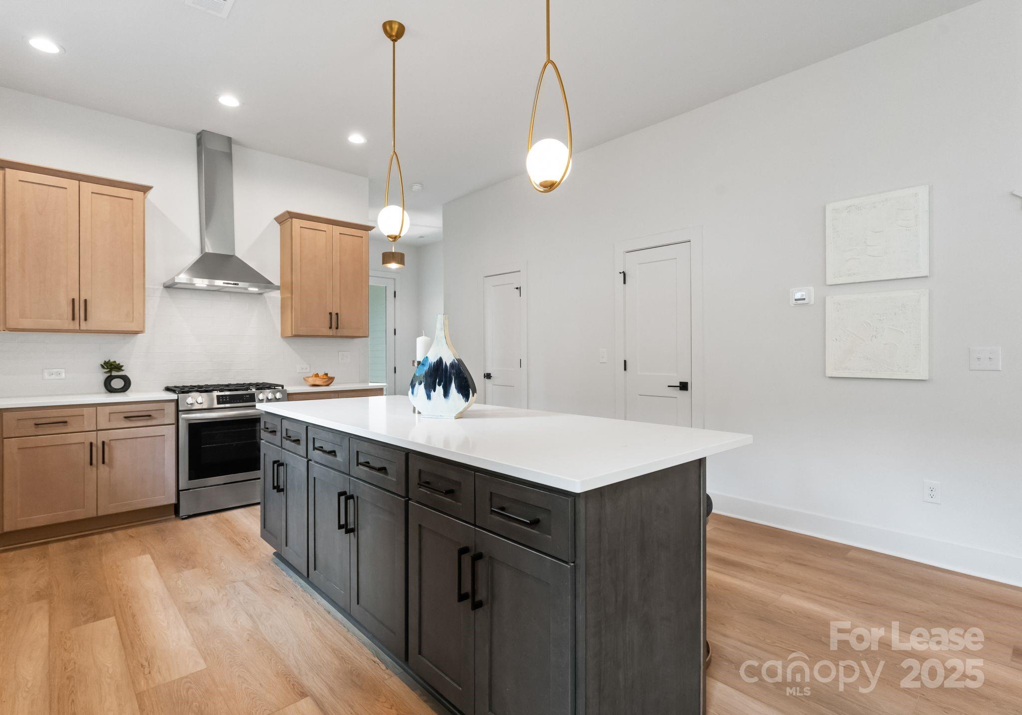 2413 Pruitt Street Charlotte, NC 28208 - Photo 30 of 35 a kitchen with a sink a stove a refrigerator and white cabinets
