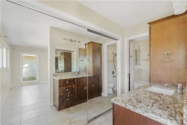 a spacious bathroom with a granite countertop sink mirror and shower
