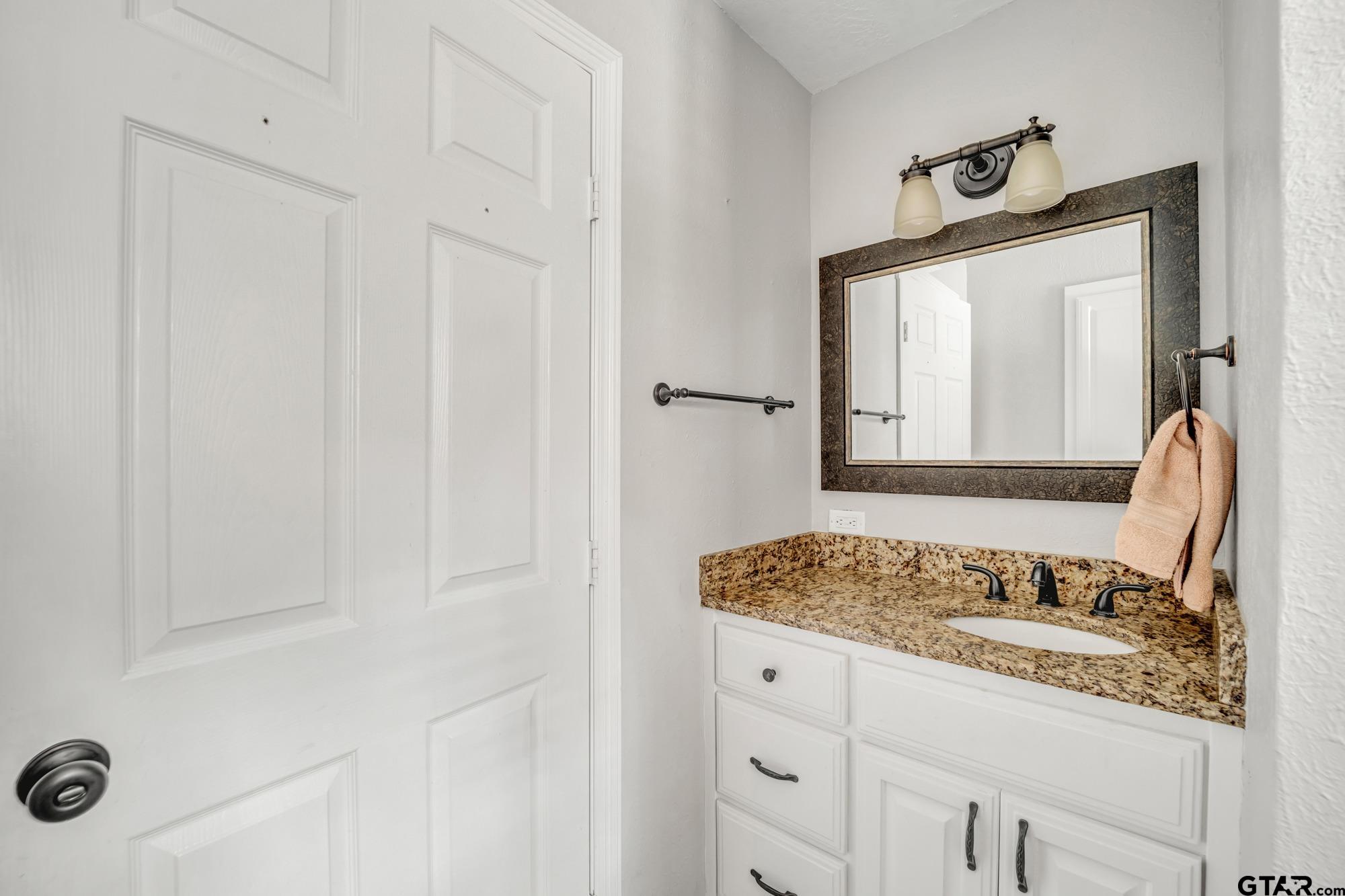 3601 Dumas Road Longview, TX 75604 - Photo 17 of 27 a bathroom with a granite countertop sink and a mirror
