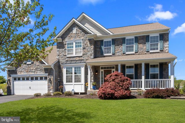 a front view of a house with a garden and yard