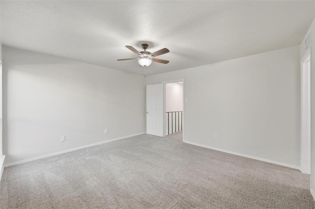 2702 Douglas Avenue, Unit 121 Dallas, TX 75219 - Photo 26 of 34 a view of an empty room with a ceiling fan and a window