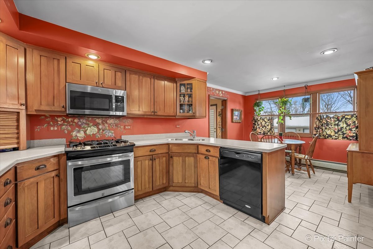 11N575 Rohrssen Road Elgin, IL 60120 - Photo 17 of 58 a kitchen with stainless steel appliances granite countertop a stove top oven microwave and view living room