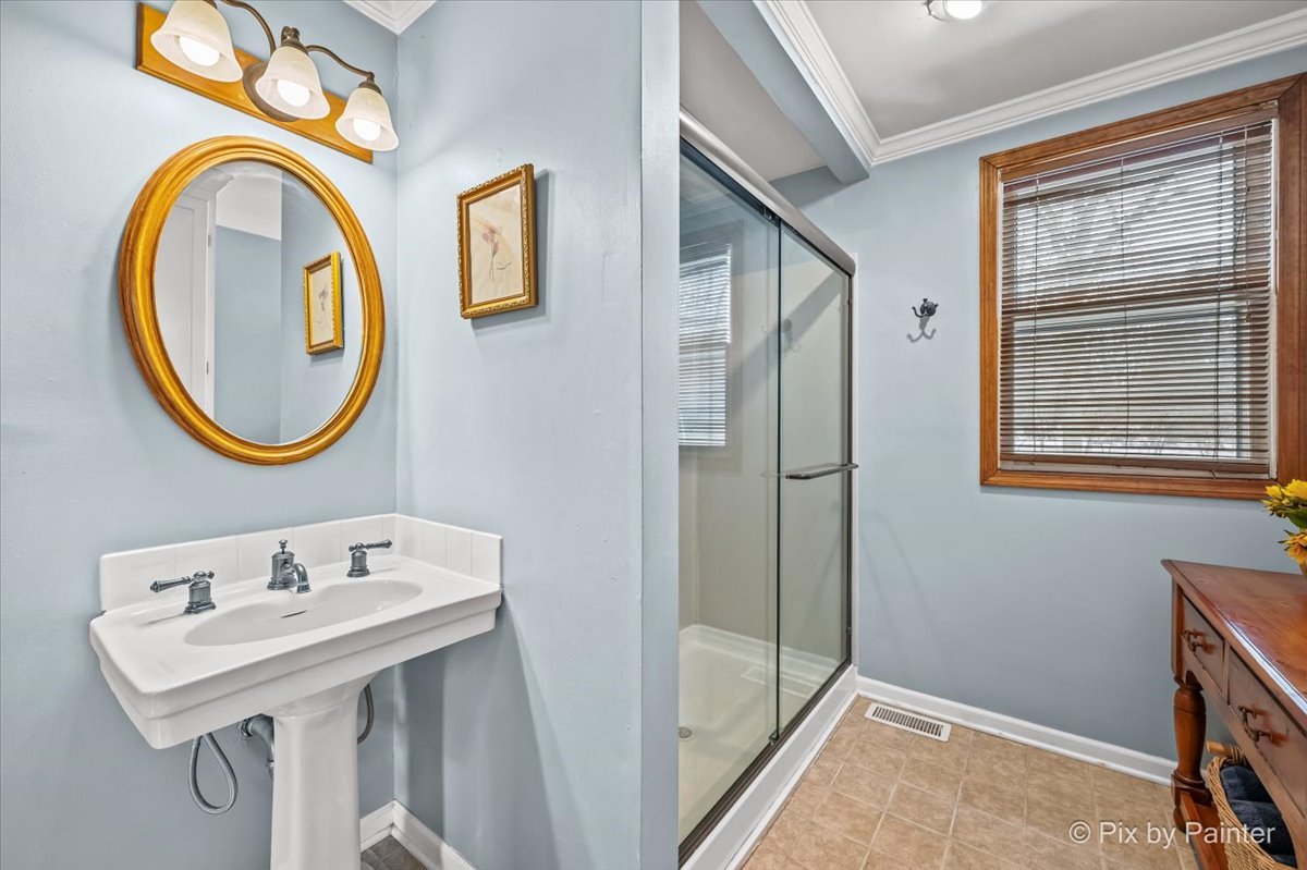 11N575 Rohrssen Road Elgin, IL 60120 - Photo 22 of 58 a bathroom with a sink a mirror and a shower