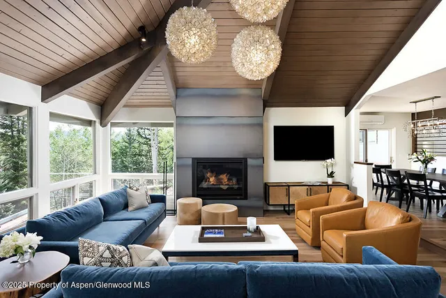 a living room with furniture a flat screen tv and a fireplace