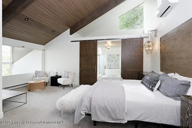 a bedroom with a bed and a large window