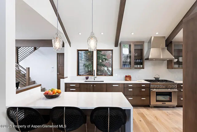 a kitchen with stainless steel appliances a sink a stove a refrigerator and cabinets