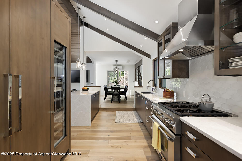 333 Faraway Road Snowmass Village, CO 81615 - Photo 4 of 29 a kitchen with stainless steel appliances granite countertop a refrigerator a stove and a wooden floors
