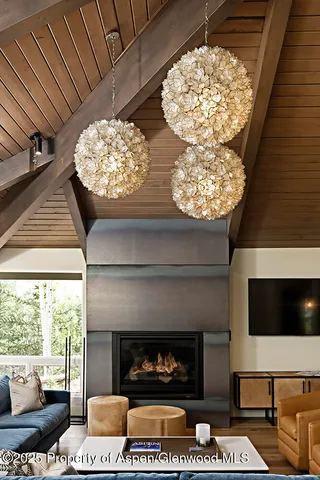 a living room with a fireplace a flat screen tv and a large window