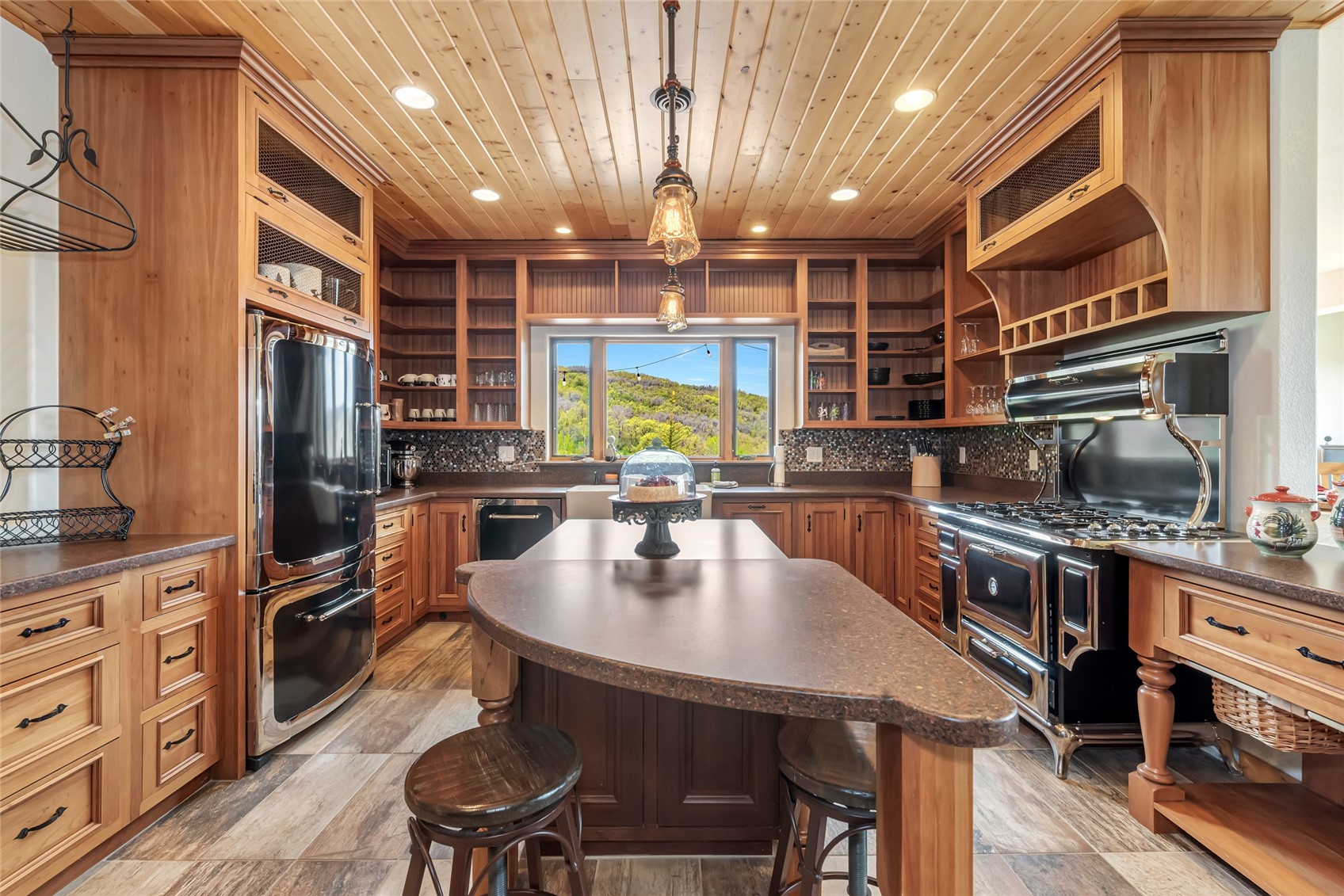31485 Deerwood Ranch Road Steamboat Springs, CO 80487 - Photo 22 of 49 a kitchen with stainless steel appliances granite countertop a stove top oven a sink a dining table and chairs with wooden floor