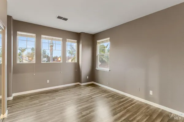 an empty room with windows and closet