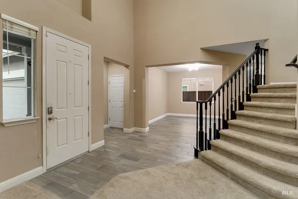 a view of a hallway with wooden floor and entryway