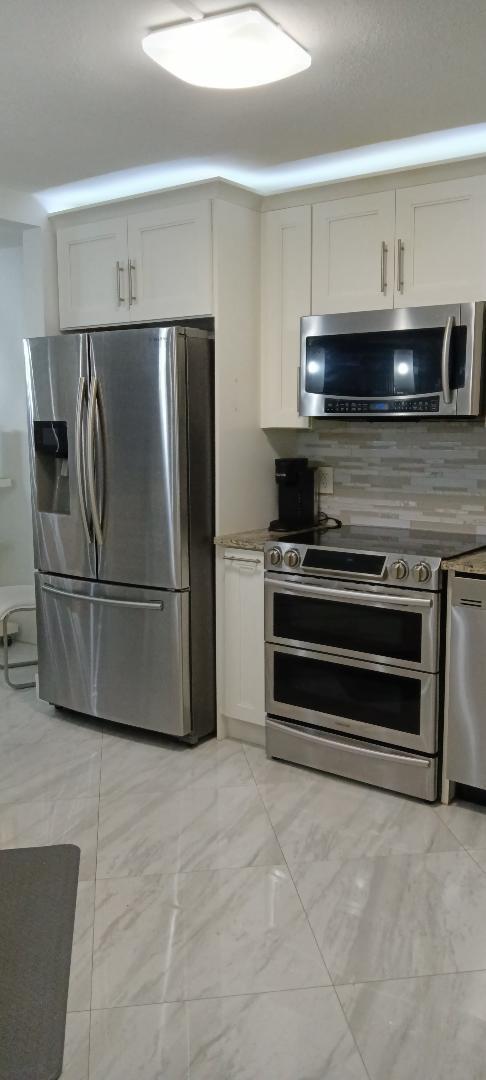 5749 Camino Del Sol, Unit 202 Boca Raton, FL 33433 - Photo 15 of 39 a kitchen with stainless steel appliances and cabinets