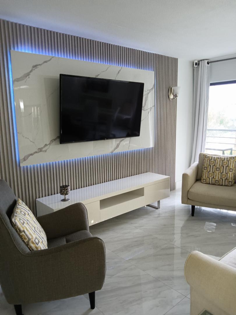 5749 Camino Del Sol, Unit 202 Boca Raton, FL 33433 - Photo 8 of 39 a living room with furniture and a flat screen tv