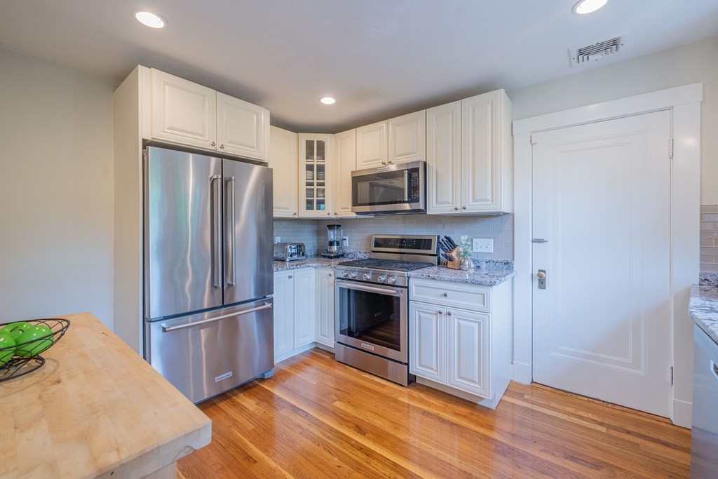 7 Maynard Street, Unit 2 Arlington, MA 02474 - Photo 16 of 42 a kitchen with a refrigerator stove and wooden cabinets
