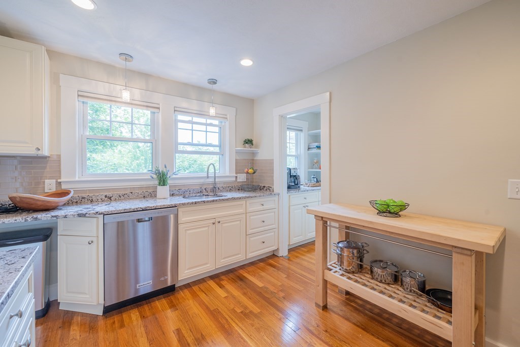7 Maynard Street, Unit 2 Arlington, MA 02474 - Photo 19 of 42 a kitchen with kitchen island granite countertop wooden floors and sink