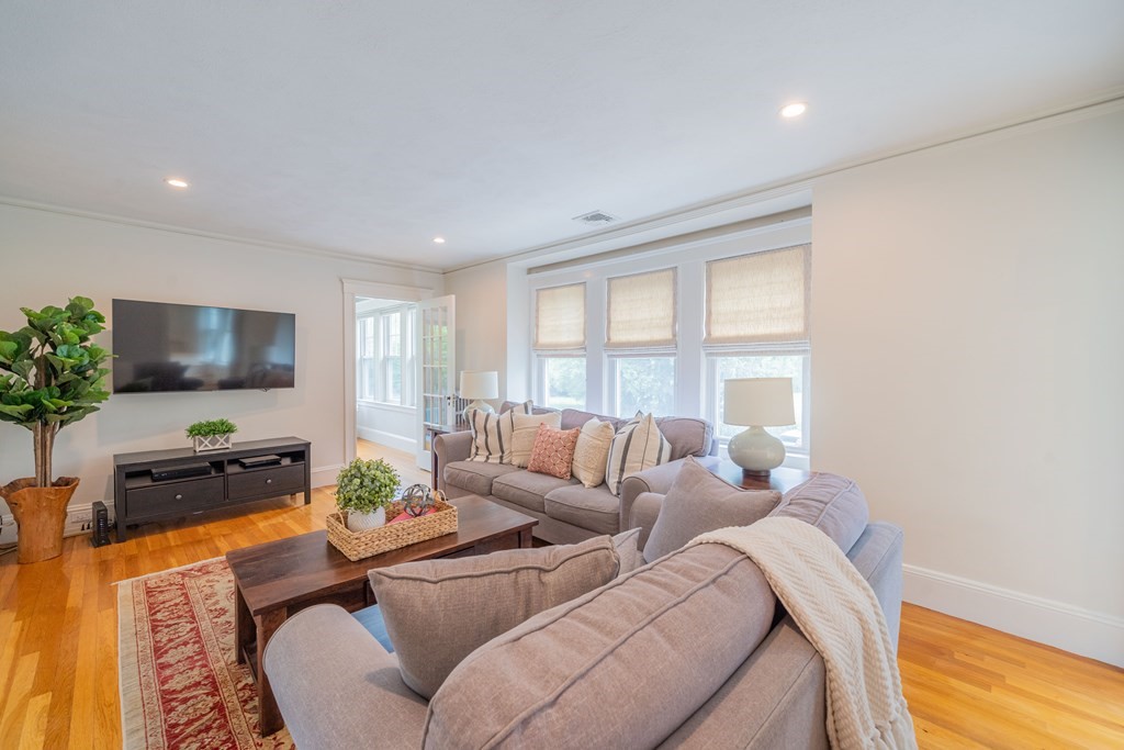 7 Maynard Street, Unit 2 Arlington, MA 02474 - Photo 3 of 42 a living room with furniture a flat screen tv and a large window