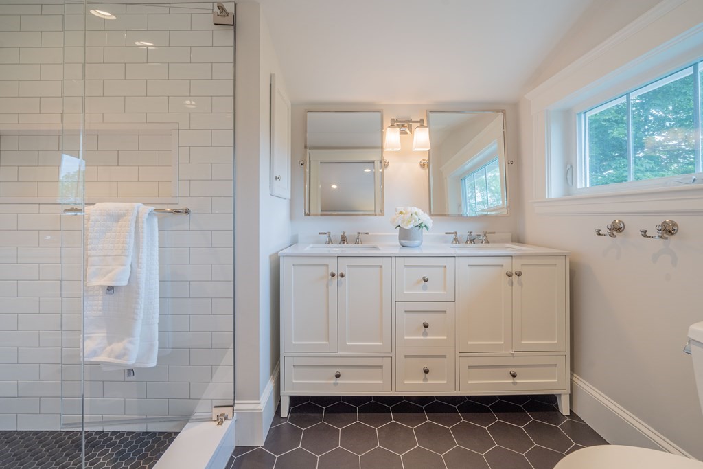 7 Maynard Street, Unit 2 Arlington, MA 02474 - Photo 40 of 42 a bathroom with a double vanity sink a mirror and a shower
