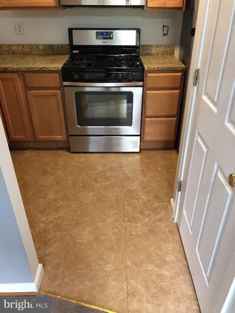 a kitchen with granite countertop a stove and a refrigerator
