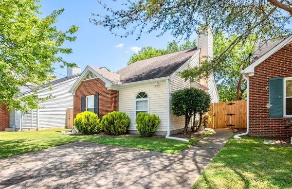 a view of a house with a yard and a large tree