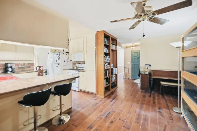 a kitchen with stainless steel appliances a dining table chairs and wooden floor