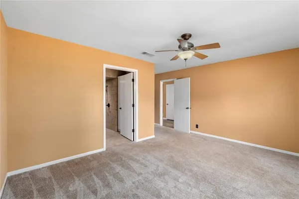 a view of a big room with a ceiling fan and a window