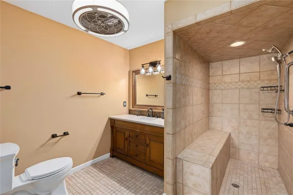 a bathroom with a granite countertop sink a toilet and shower