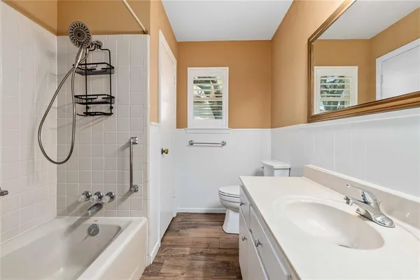 a bathroom with a granite countertop sink a mirror a vanity and a bathtub