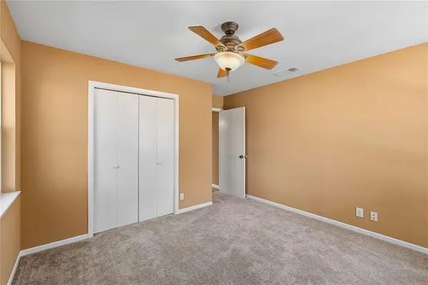 an empty room with a ceiling fan and a window