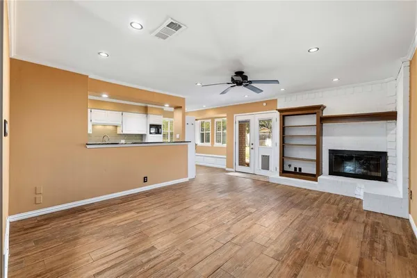 a large kitchen with stainless steel appliances granite countertop a large window and a fireplace