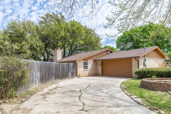 a front view of a house with a yard and tree s