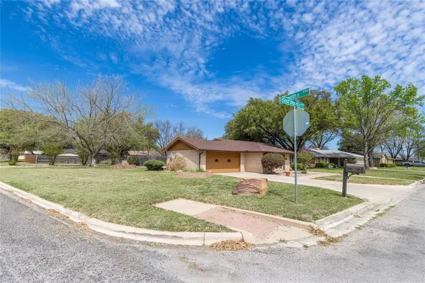 a view of a yard with plants and trees