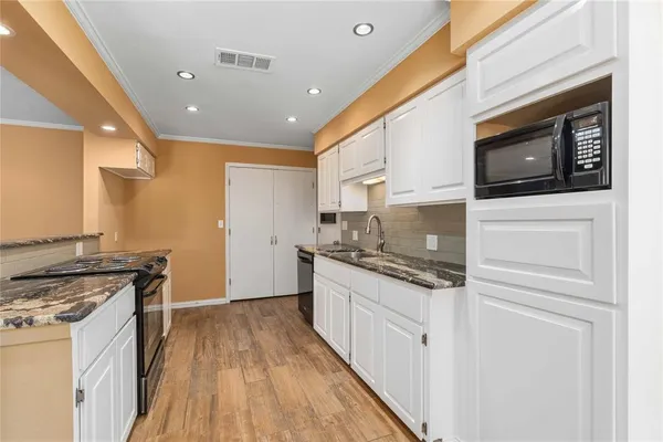 a kitchen with granite countertop a sink and a stove top oven
