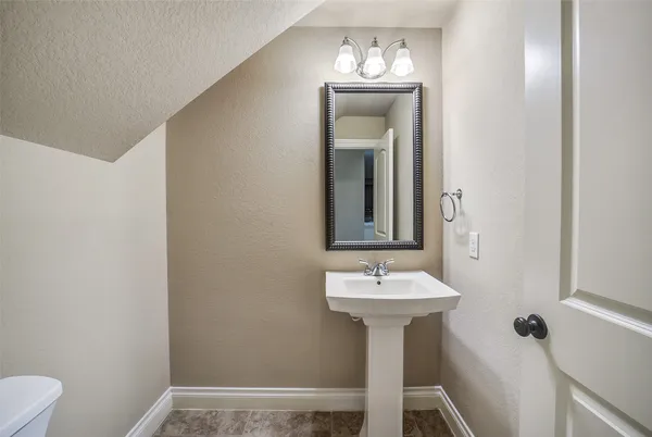 a bathroom with a sink toilet and a mirror