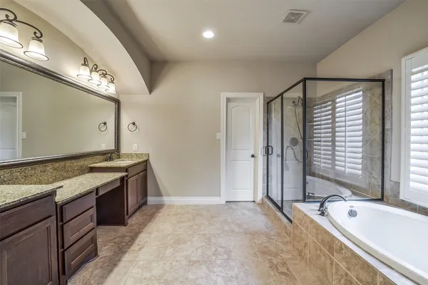 a spacious bathroom with a granite countertop tub sink and mirror