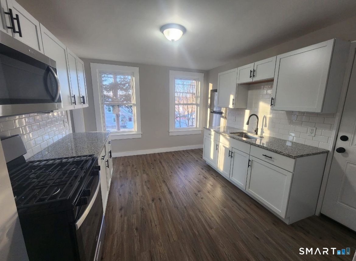 282 Ward Street Wallingford, CT 06492 - Photo 2 of 6 a kitchen with stainless steel appliances granite countertop a stove a sink and a microwave