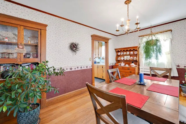a dining room with furniture a chandelier and wooden floor