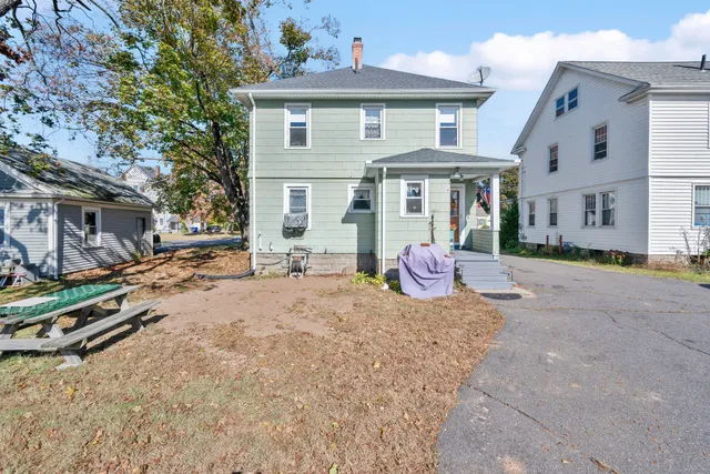 a backyard of a house with barbeque oven table and chairs