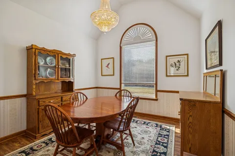 a view of a dining room with furniture and chandelier