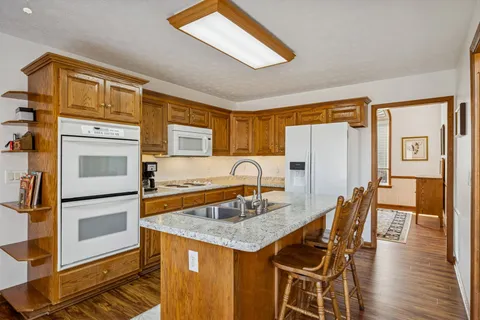 a kitchen with stainless steel appliances granite countertop a sink and a refrigerator