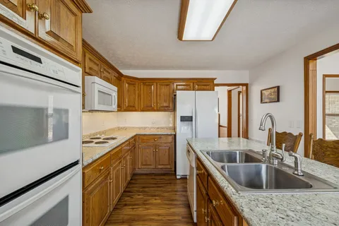 a kitchen with stainless steel appliances granite countertop sink stove and refrigerator