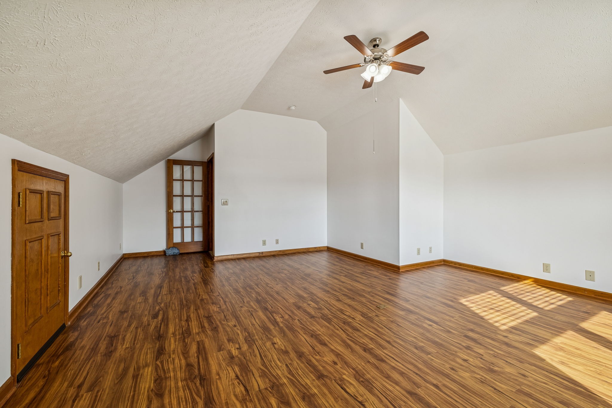 1457 Absher Branch Road Westmoreland, TN 37186 - Photo 35 of 74 an empty room with wooden floor chandelier fan and windows