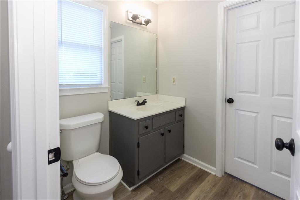 374 McGiboney Road Covington, GA 30016 - Photo 15 of 29 a bathroom with a toilet a sink a mirror and a window