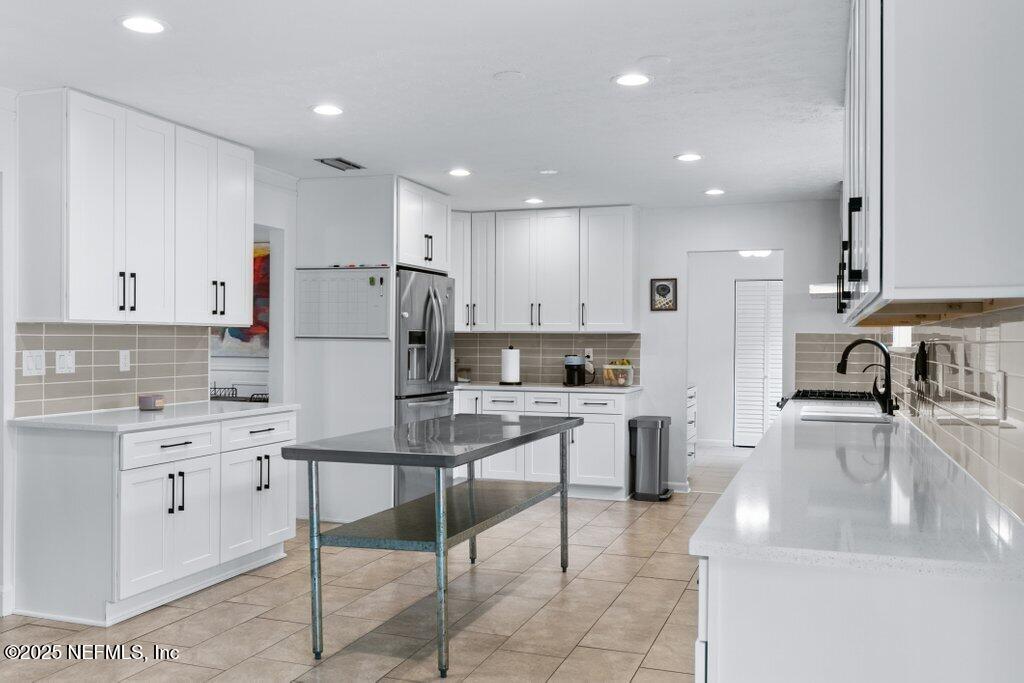 9480 Pickwick Drive Jacksonville, FL 32257 - Photo 14 of 43 a kitchen with white cabinets and stainless steel appliances