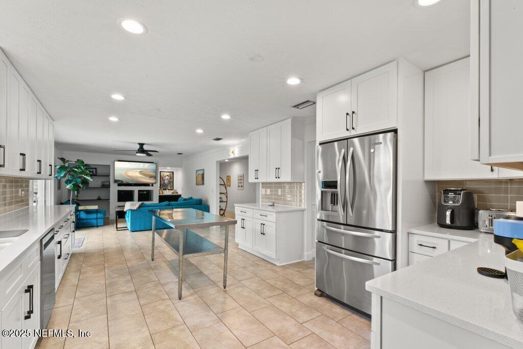 9480 Pickwick Drive Jacksonville, FL 32257 - Photo 17 of 43 a kitchen with stainless steel appliances kitchen island granite countertop dining table chair and a refrigerator