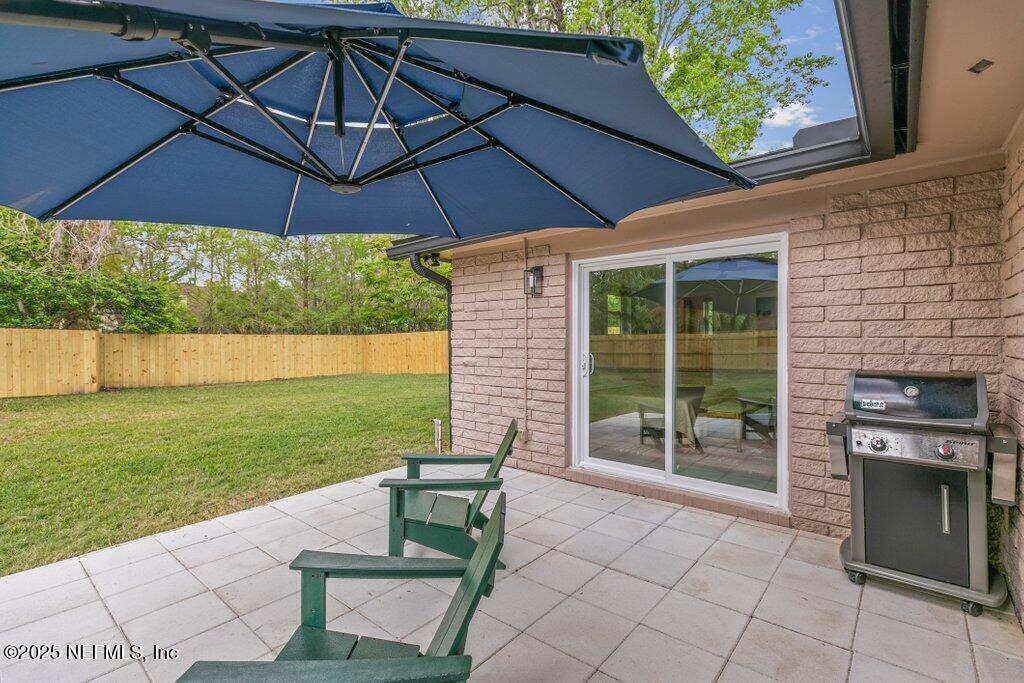 9480 Pickwick Drive Jacksonville, FL 32257 - Photo 33 of 43 a view of a backyard with table and chairs under an umbrella